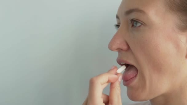 女性はカルシウムの錠剤を飲み込み、水で飲む - 映像、動画