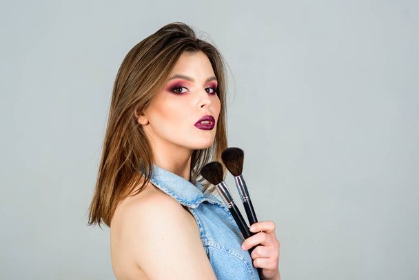 fashion makeup visage. beauty hairdresser salon. Lipstick and eyeshadow. sensual woman with long hair, style. sexuality. skincare cosmetics. sexy woman with professional make up brush. copy space - Fotó, kép