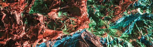 panoramic shot of glossy crumpled foil with colorful lighting reflection - Photo, Image