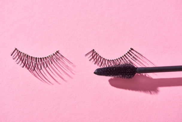 top view of false eyelashes and brush on pink background  - Photo, Image