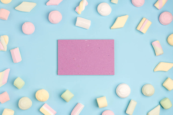 Blue paper background with marshmallow and notepad. Place for your text. Cozy sweet background - Photo, image