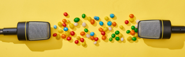 панорамний знімок мікрофонів і цукерок на яскравому і барвистому фоні
  - Фото, зображення