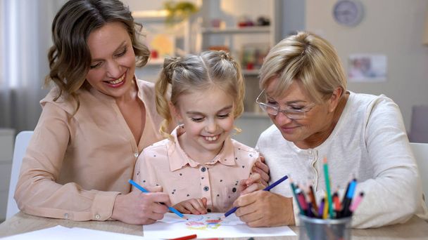 Elderly mother, daughter and grandchild drawing by color pencils, time together - 写真・画像