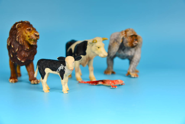 青い背景にプラスチック製のおもちゃの動物、赤ちゃんの小さな動物. - 写真・画像