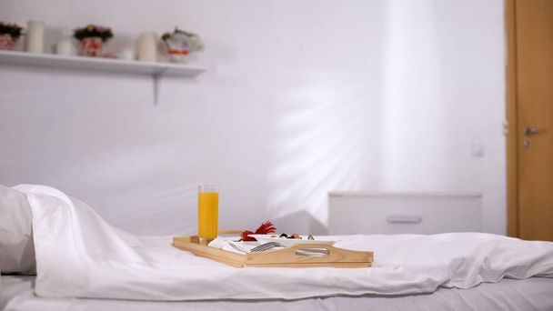 Tray with food standing on white bed, food order in hotel room, quality service - Foto, Bild