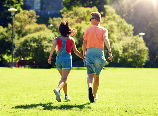 happy teenage couple walking at summer park - Zdjęcie, obraz