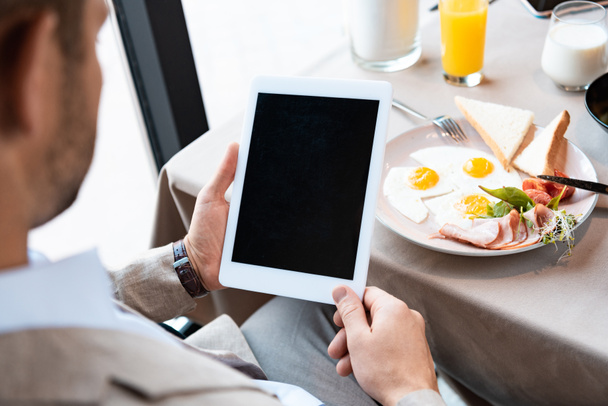 abgeschnittene Ansicht von Geschäftsmann mit digitalem Tablet mit leerem Bildschirm im Café - Foto, Bild