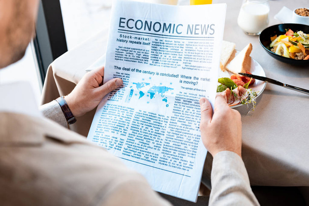 cropped view of businessman reading newspaper in cafe - Photo, Image