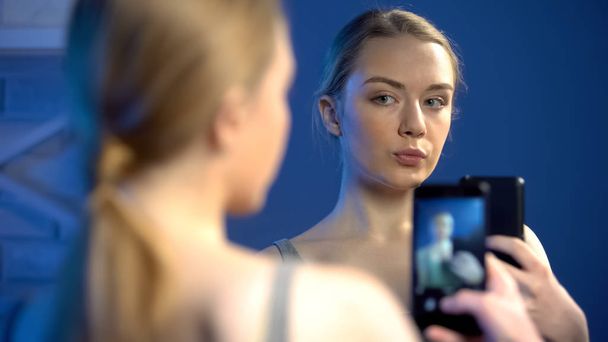 Pretty teenage girl posing for selfie in front of mirror, social net addiction - Foto, imagen