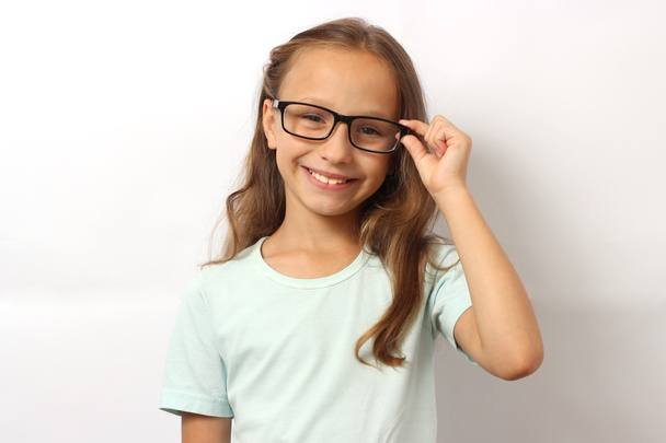 Porträt eines niedlichen lächelnden Mädchens mit Brille auf farbigem Hintergrund. - Foto, Bild