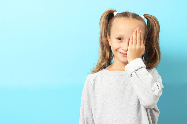 little cute cheerful girl passes an eye test in the office of an ophthalmologist - 写真・画像