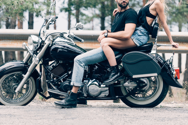 recortado vista de joven pareja de ciclistas en negro motocicleta en carretera
 - Foto, Imagen
