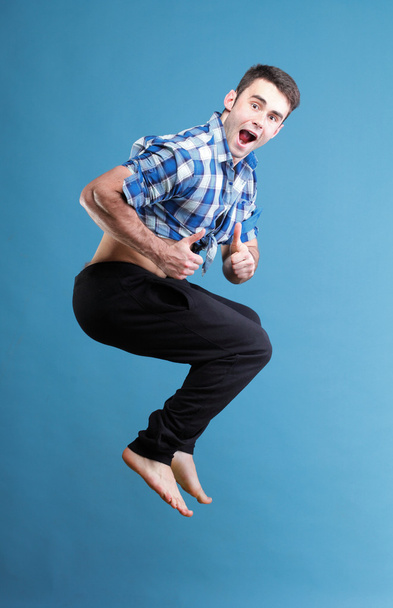 Young man jumping isolated gray background - Foto, afbeelding
