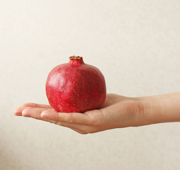 Granate. El fruto de la granada yace en la mano
. - Foto, Imagen