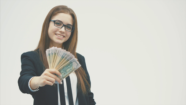 Retrato de una joven feliz con ropa de oficina, sosteniendo un abanico de dinero en una mano alargada
. - Metraje, vídeo