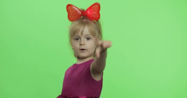 Chica en vestido morado bailando y muestra un dedo hacia adelante. Feliz niña. Clave de croma
 - Imágenes, Vídeo