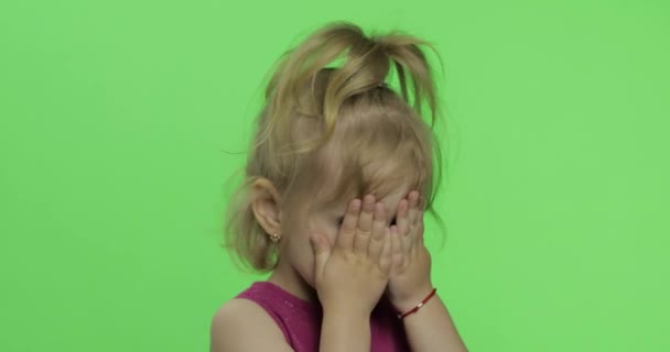 Kinderporträt in lila Kleid. verbirgt ihr Gesicht mit Händen und Klauen. Chroma-Schlüssel - Filmmaterial, Video