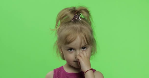Kinderporträt in lila Kleid. Mädchen beim Nasenpicken. Chroma-Schlüssel - Filmmaterial, Video