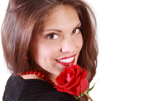 Happy young woman with red rose on her shoulder looks at camera - Foto, Imagem