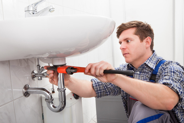 Portrait of male plumber fixing a sink - Photo, image
