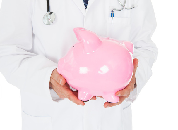 Male Doctor With Piggy Bank - Foto, immagini