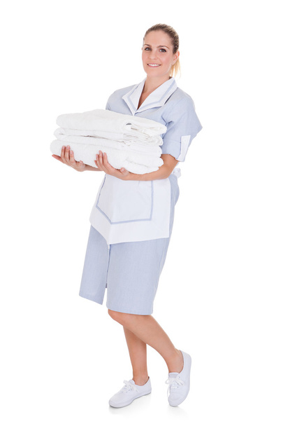 Happy Young Maid Holding Towels - Foto, afbeelding