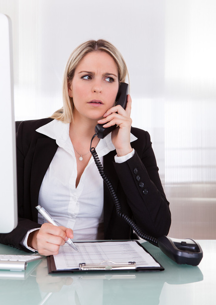 Shocked businesswoman talking on telephone - Photo, Image
