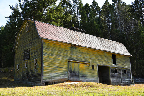 Uma imagem de um velho celeiro agrícola de madeira com tinta amarela desbotada
.  - Foto, Imagem