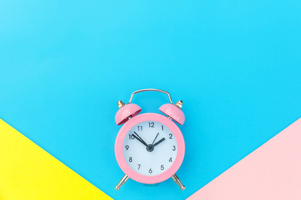 Vintage alarm clock isolated on blue yellow pink pastel colorful trendy geometric background - Foto, afbeelding