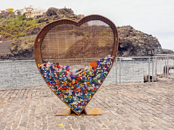 Велике іржаве прозоре металеве серце як контейнер для переробки пластикових закриттів
    - Фото, зображення
