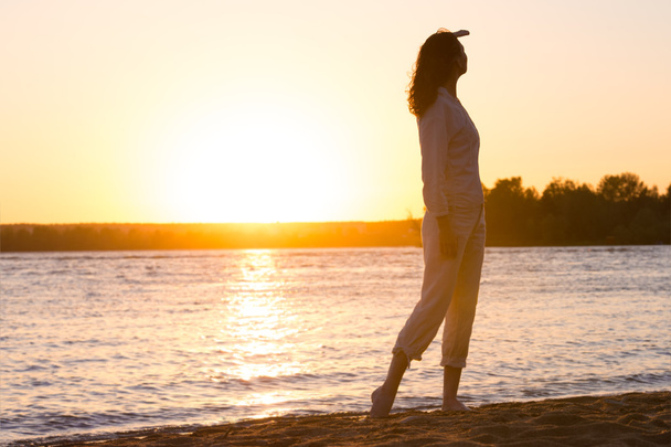 Beautiful woman in natural white shirt looking to the golden sun - Fotoğraf, Görsel