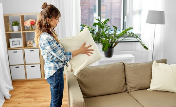 asian woman arranging sofa cushions at home - Fotografie, Obrázek