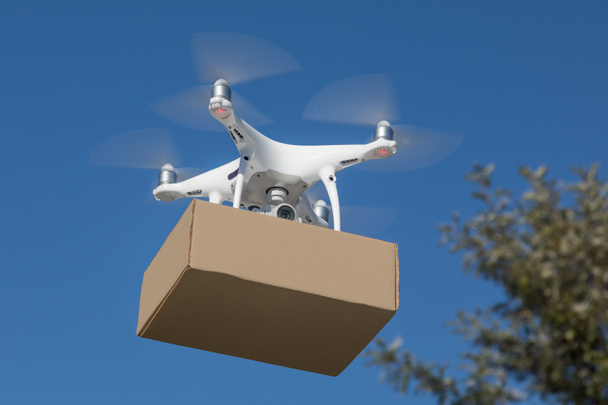 Беспилотные летательные аппараты (БЛА) Quadcopter Drone Delivering Package
 - Фото, изображение