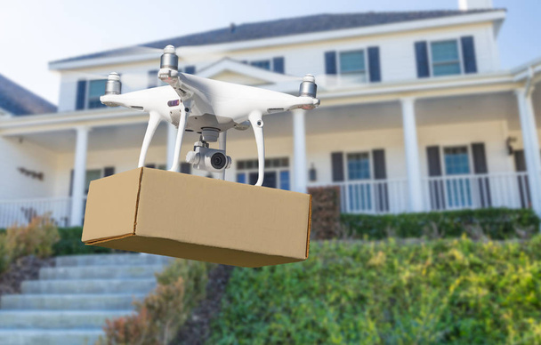 Drone Quadcopter du système d'aéronef sans pilote (UAV) livrant le paquet à la maison
 - Photo, image
