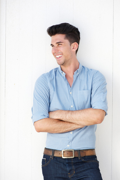 šťastný mladý muž stojící proti bílé zdi venku - Fotografie, Obrázek