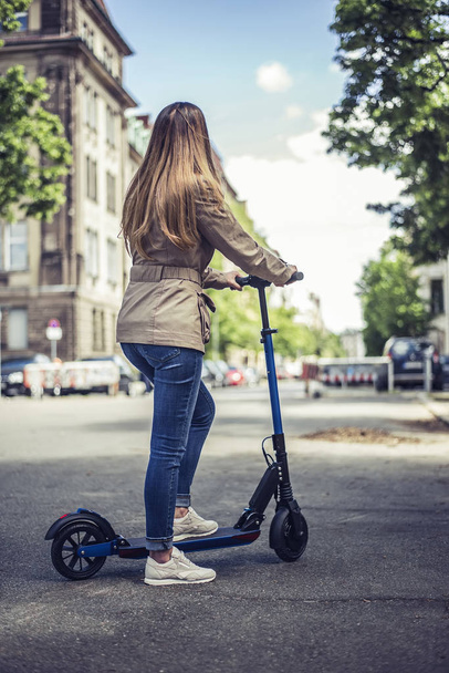 jeune femme avec e-scooter, vue arrière
 - Photo, image