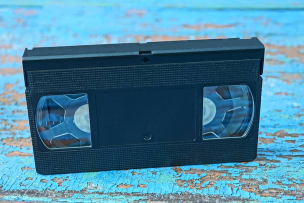  vieille bande vidéo en plastique sur une table bleue minable
 - Photo, image
