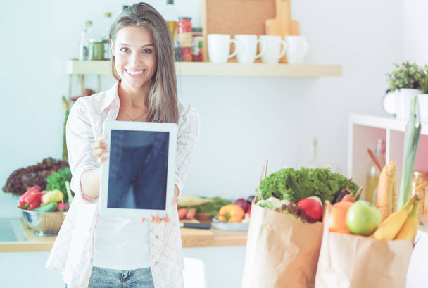 Young woman in the kitchen, using her ipad. Young woman - Foto, imagen