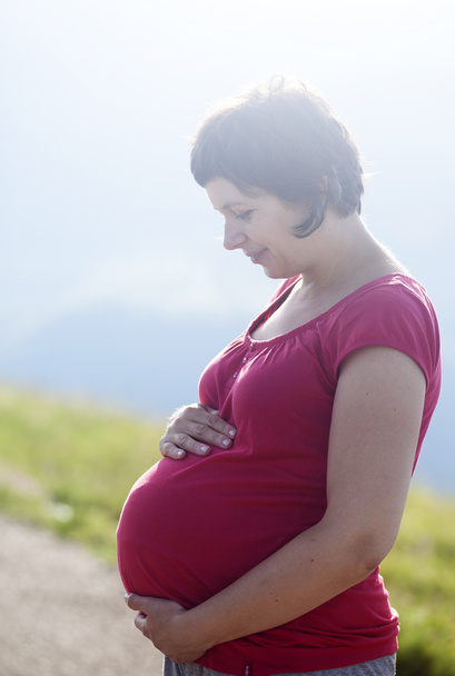 Pregnant happy woman in a field outdoors - Foto, Imagen