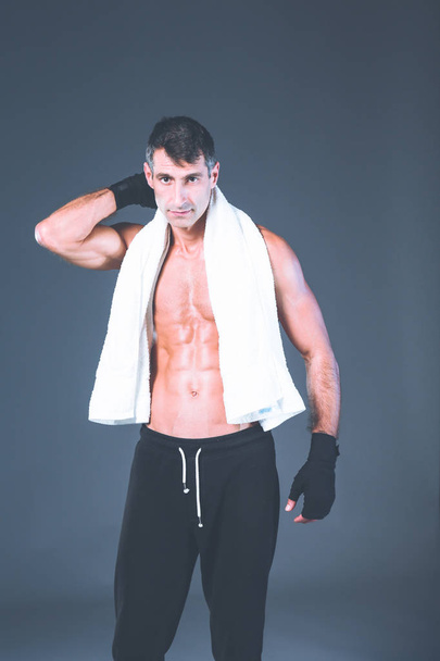 Strong athletic man standing on black background. - Фото, зображення