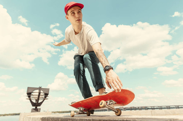Skateboarder doing a trick at the citys street in sunny day - 写真・画像