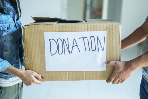 Mujer joven dando una caja de donaciones para ser voluntaria
 - Foto, imagen