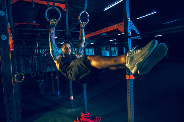 Young healthy man athlete doing exercise in the gym - 写真・画像