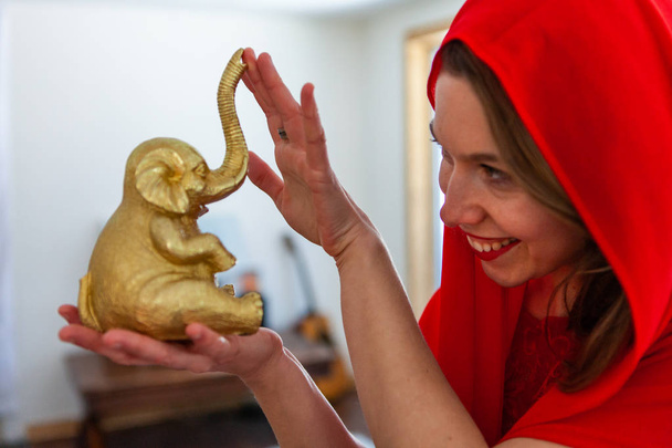 Frau hält goldene Elefantenfigur. - Foto, Bild
