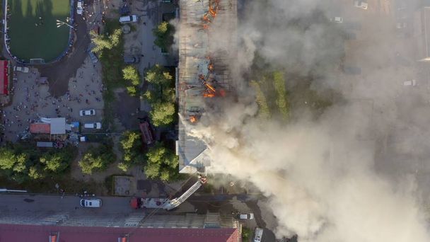 Toit en feu d'un immeuble résidentiel de grande hauteur, nuages de fumée provenant du feu. vue de dessus
 - Photo, image