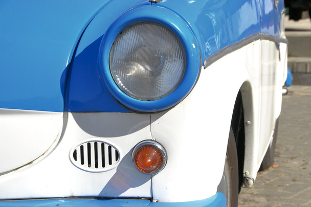 Сине-белый классический автомобиль на обочине дороги
 - Фото, изображение