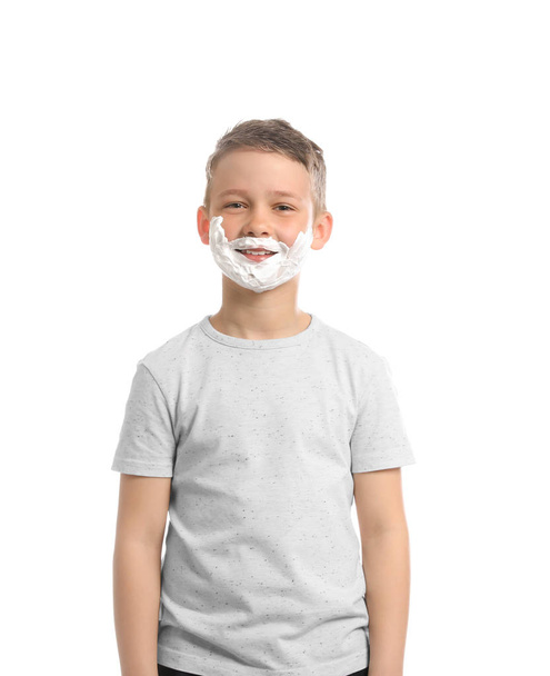 Happy boy with shaving foam on face against white background - Фото, изображение