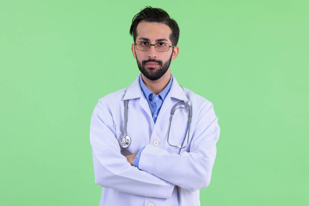 Young bearded Persian man doctor with arms crossed - Fotoğraf, Görsel