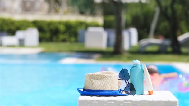 Zonnecrème, hoed, zonnebril bij zwembad - Video