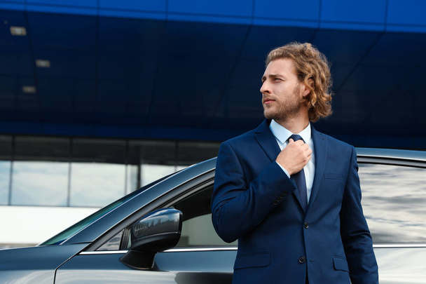 Attractive young man near luxury car outdoors - 写真・画像